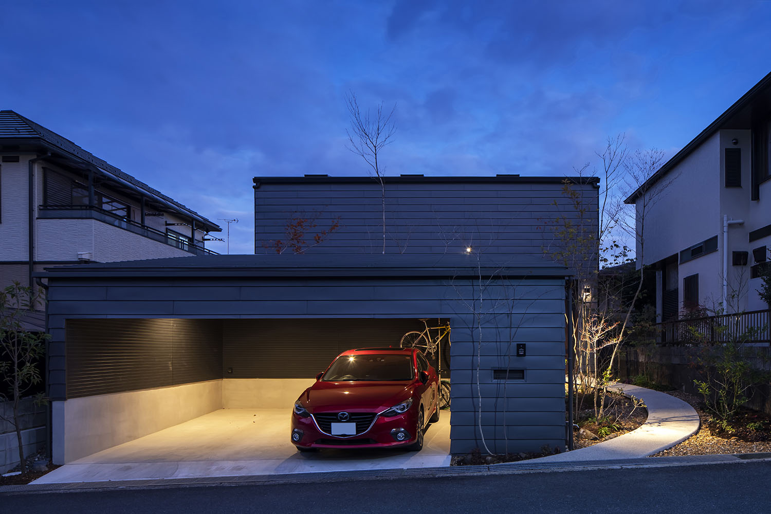 インナーガレージの中に赤い車が一台収納されている、夜の様子・景の家 注文住宅・デザイン住宅建築実例_『CASE698 「景の家」』_外観