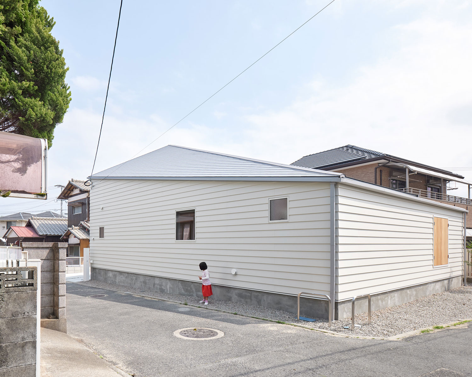 白い壁の住宅の前に子供が立っている・フリーダムアーキテクツの事例 注文住宅・デザイン住宅建築実例_『CASE702 yacht』_外観