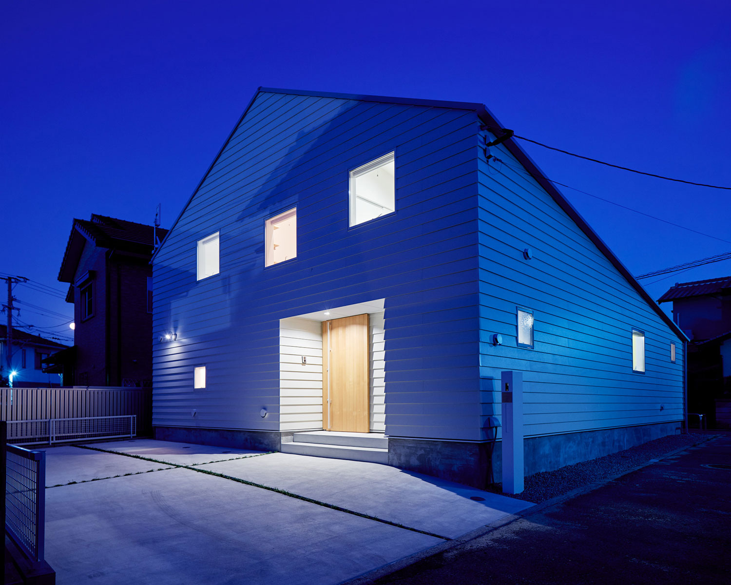 窓から室内の光が漏れている三角屋根の住宅・フリーダムアーキテクツの事例 注文住宅・デザイン住宅建築実例_『CASE702 yacht』_外観