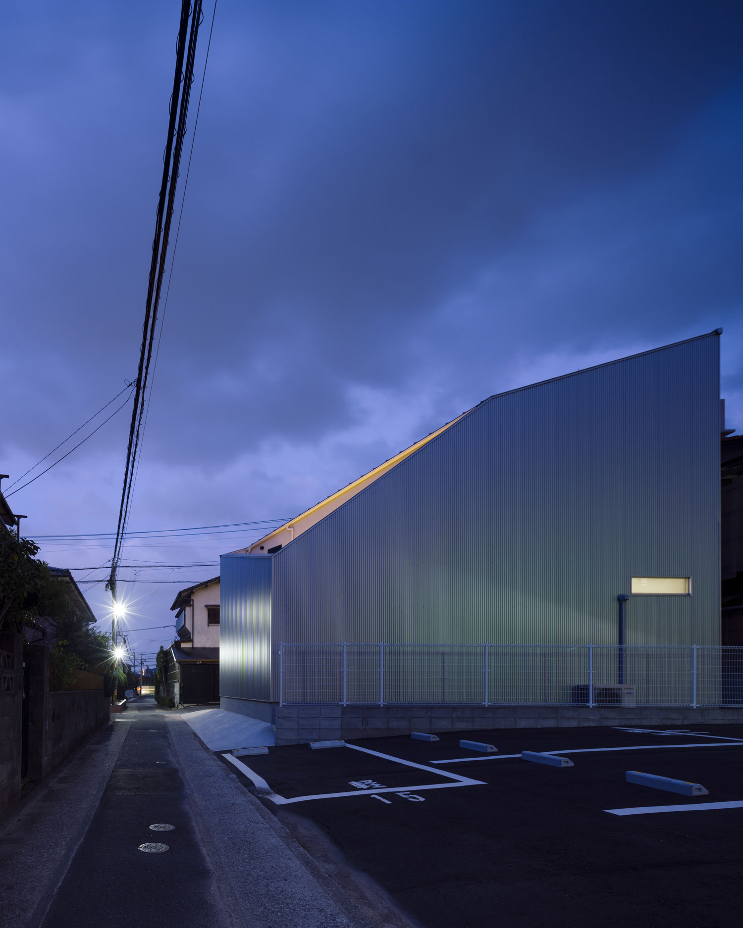 夜に、窓の少ない斜め屋根の住宅が建っている様子・フリーダムアーキテクツの事例 注文住宅・デザイン住宅建築実例_『CASE703 /』_外観