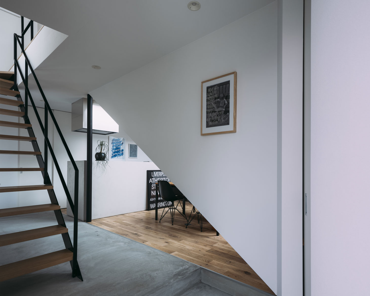 モルタルの玄関を入るとすぐにスケルトン階段やリビングが見える様子・フリーダムアーキテクツの事例 注文住宅・デザイン住宅建築実例_『CASE703 /』_玄関