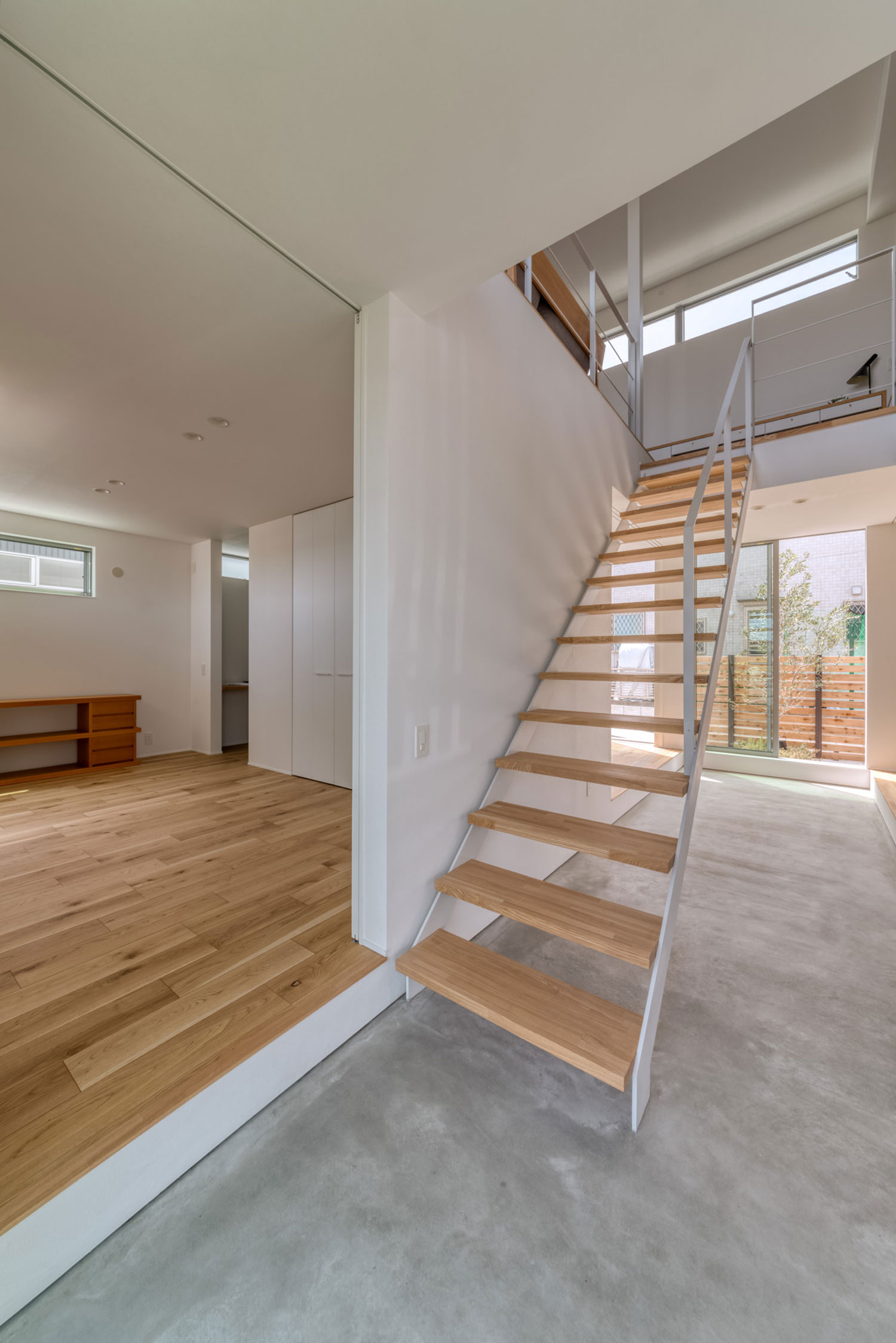 モルタルの玄関と繋がる木製のスケルトン階段・フリーダムアーキテクツの事例 注文住宅・デザイン住宅建築実例_『CASE704 with a view』_階段