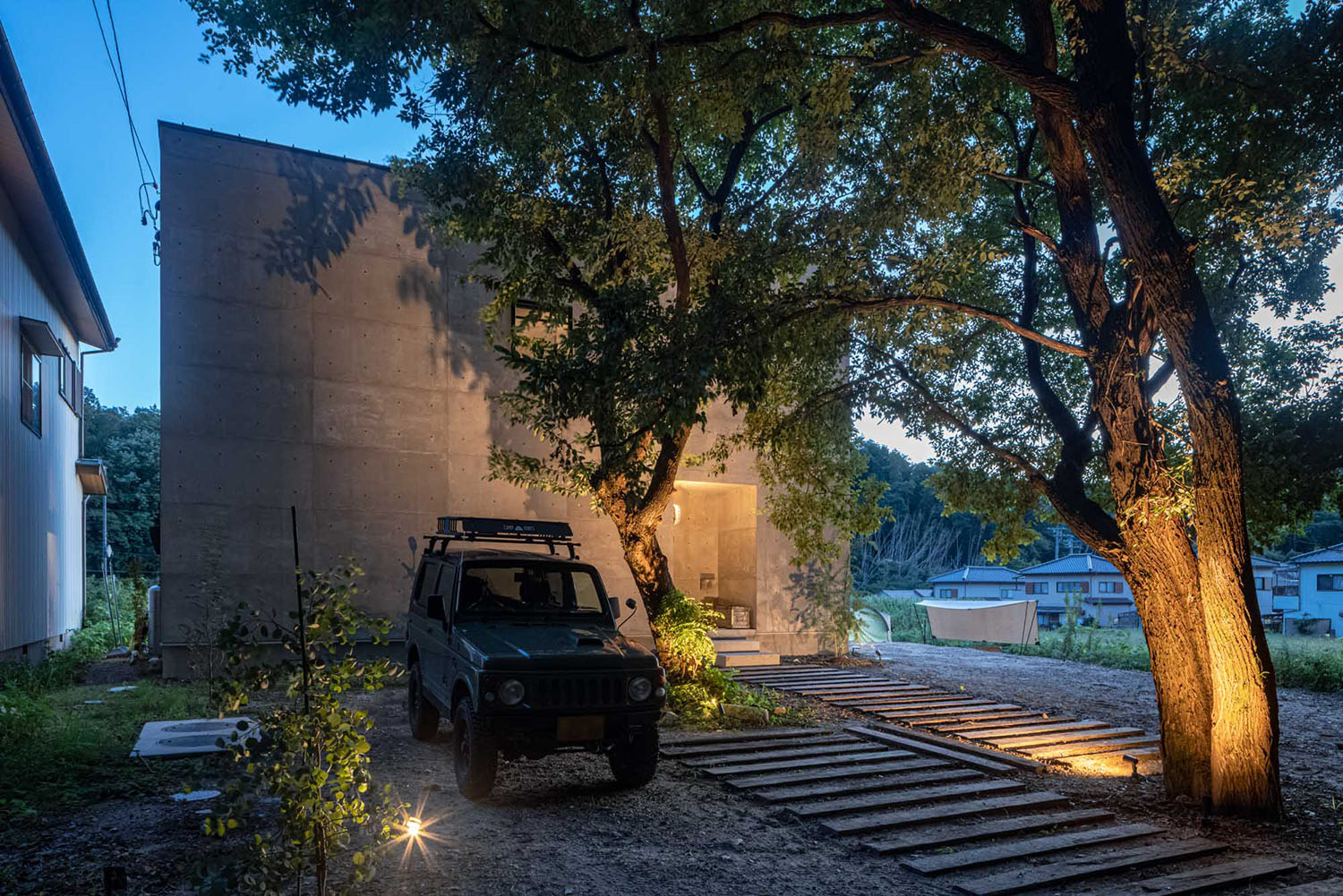 屋外照明に照らされた大きな木が目の前にある家・フリーダムアーキテクツの事例 注文住宅・デザイン住宅建築実例_『CASE707 IGNIS』_外観