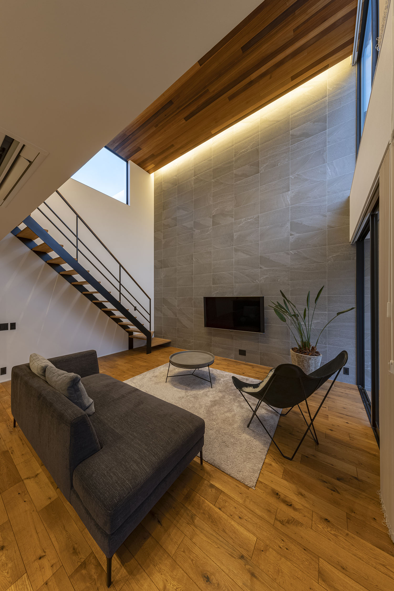 天井の間接照明に照らされた吹き抜けのあるリビング・フリーダムアーキテクツの事例 注文住宅・デザイン住宅建築実例_『CASE709 sumika』_LDK