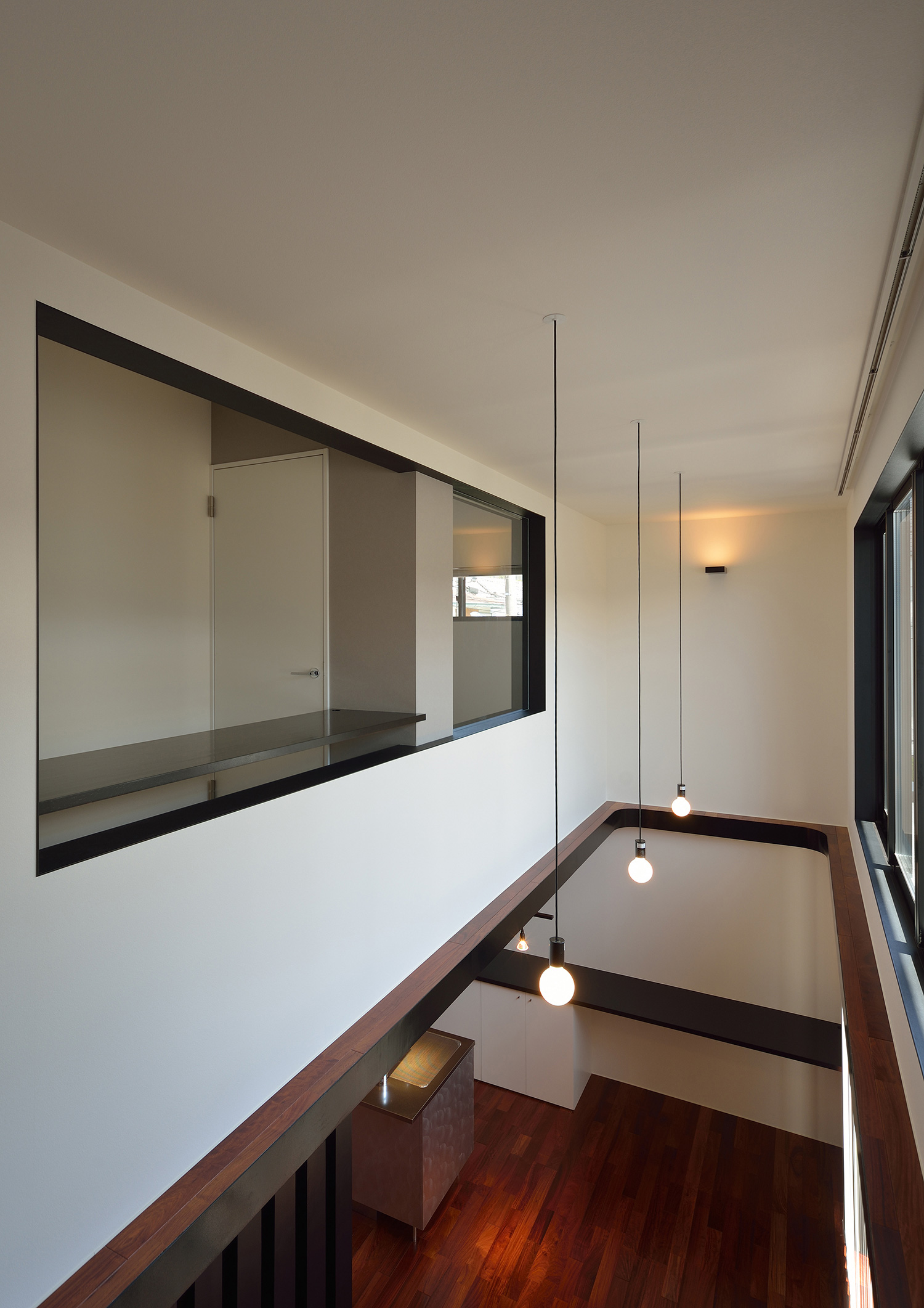 吹き抜けに面した室内窓がある二階の廊下・デザイン住宅