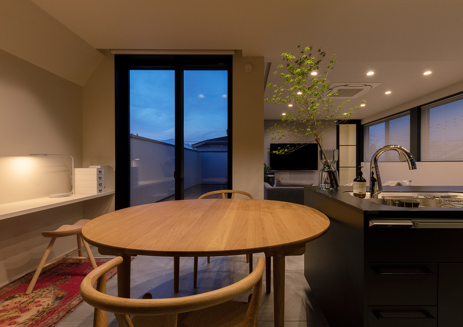 木の丸いテーブルからバルコニーが見える様子・フリーダムアーキテクツの事例 注文住宅・デザイン住宅建築実例_『CASE748 バスケットコートのある家』_LDK