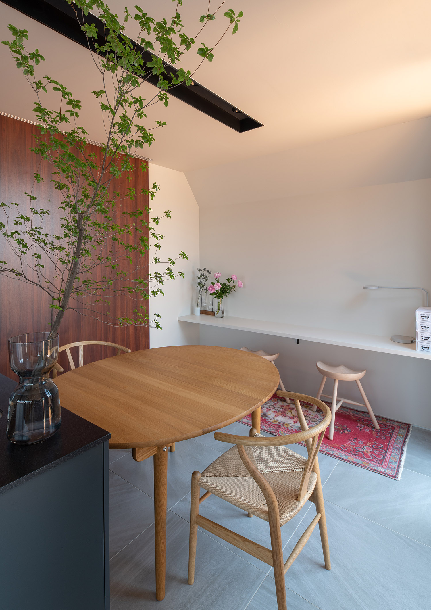 木の丸いテーブルの横に壁付けのデスクスペースが設けられている・フリーダムアーキテクツの事例 注文住宅・デザイン住宅建築実例_『CASE748 バスケットコートのある家』_LDK