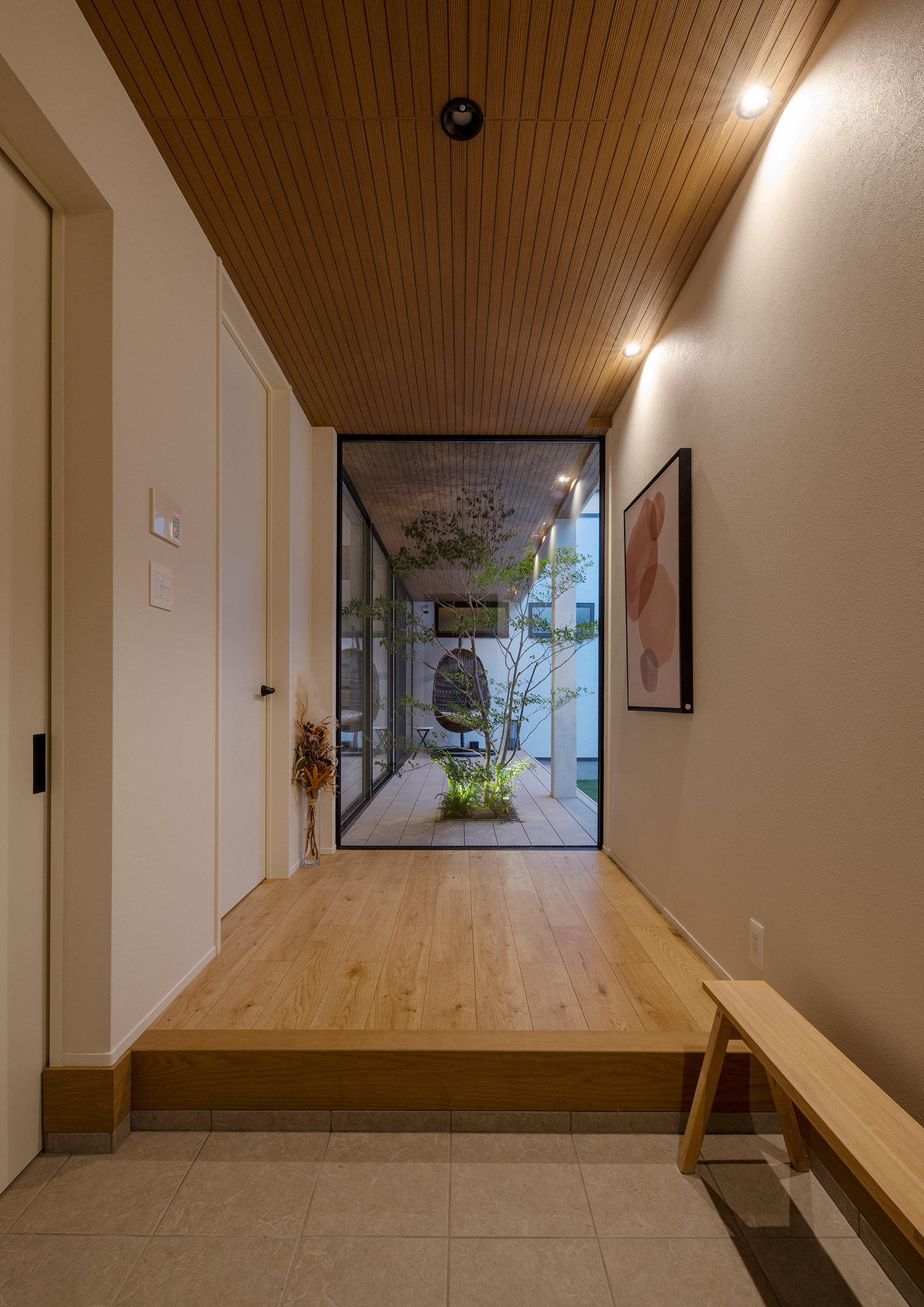 木目の天井にダウンライトが取り付けられた、突き当りに窓がある廊下・デザイン住宅 注文住宅・デザイン住宅建築実例_『CASE757 トキノエンガワ』_玄関