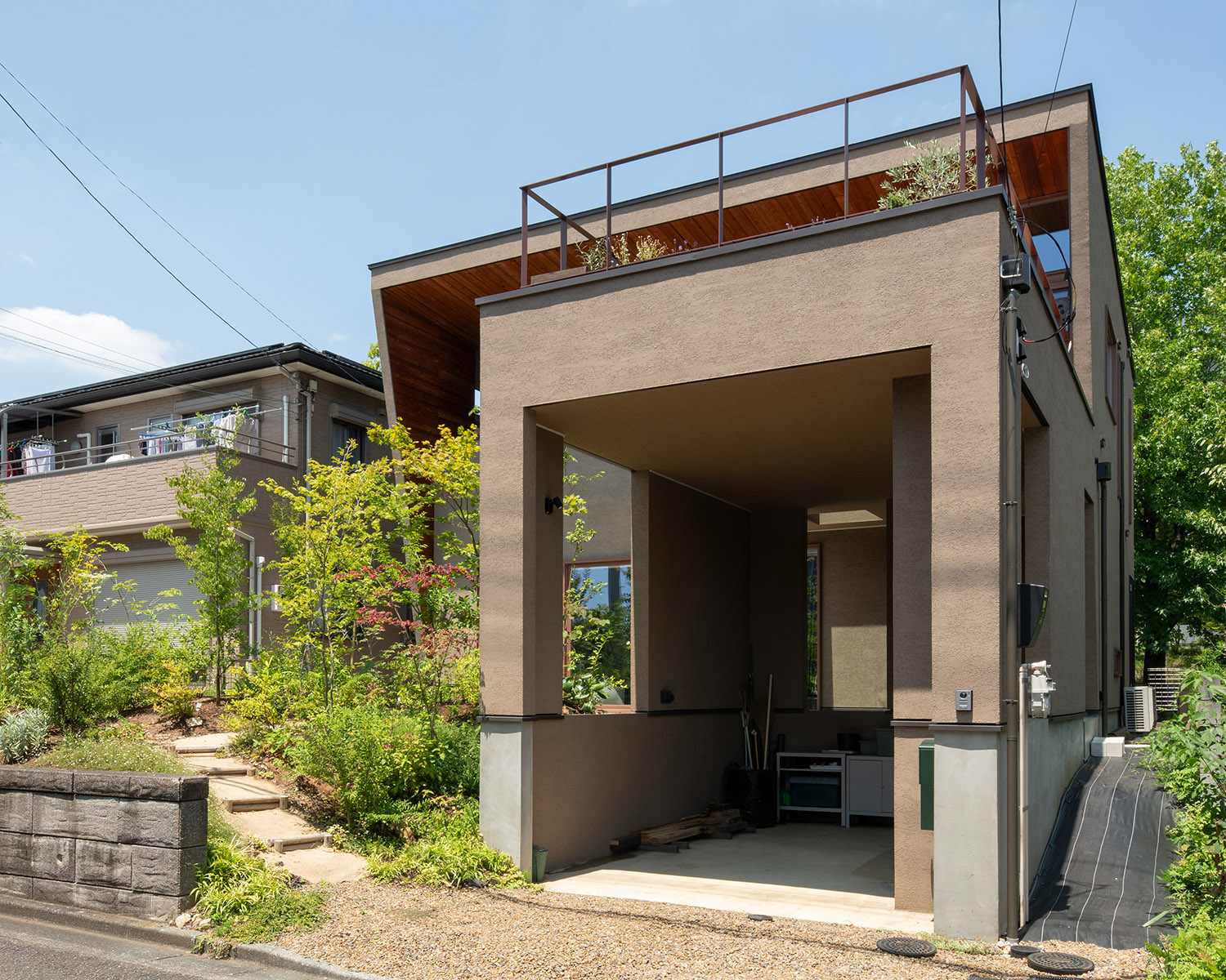 アプロ―チの隣にインナーガレージがあるおしゃれな家の外観・デザイン住宅 注文住宅・デザイン住宅建築実例_『CASE767 ウチソトのドマ』_外観