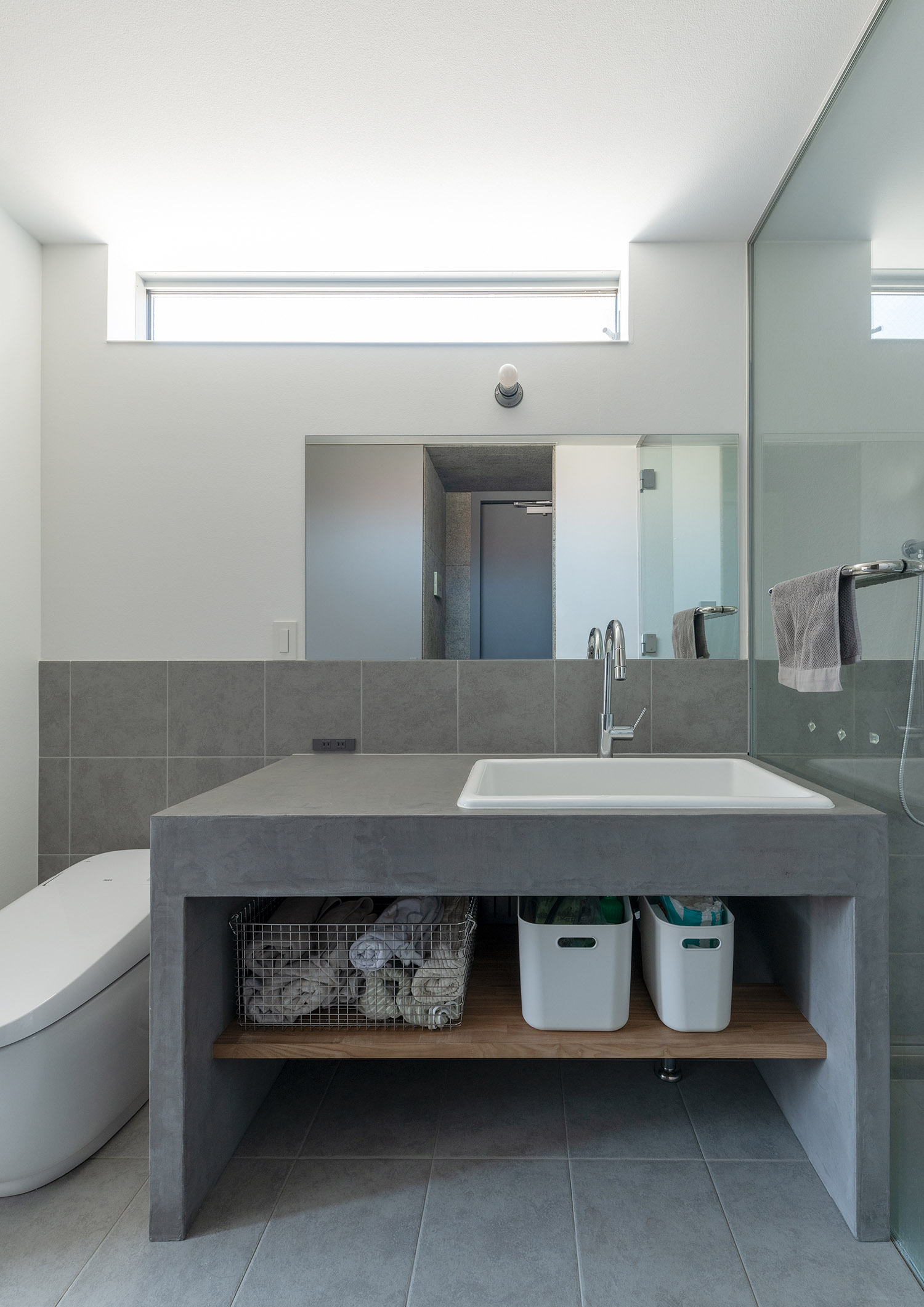 グレーのシンプルな洗面台と同じ空間にあるトイレ・デザイン住宅 注文住宅・デザイン住宅建築実例_『CASE772 大らかにツナガル』_浴室・洗面所