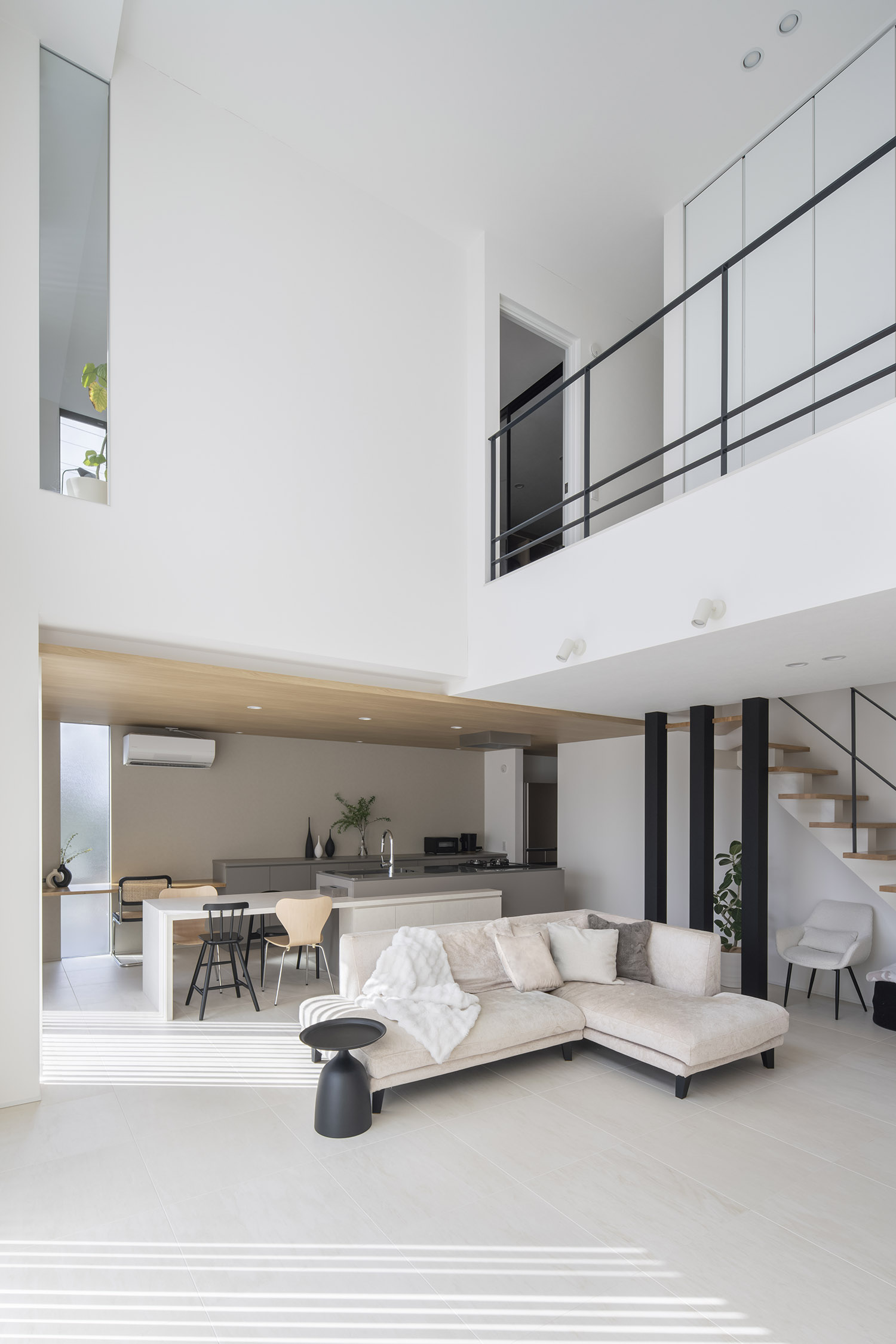 吹き抜けに面したアイアンの手すり付きの廊下があるLDK・デザイン住宅 注文住宅・デザイン住宅建築実例_『CASE768 Living with light』_LDK